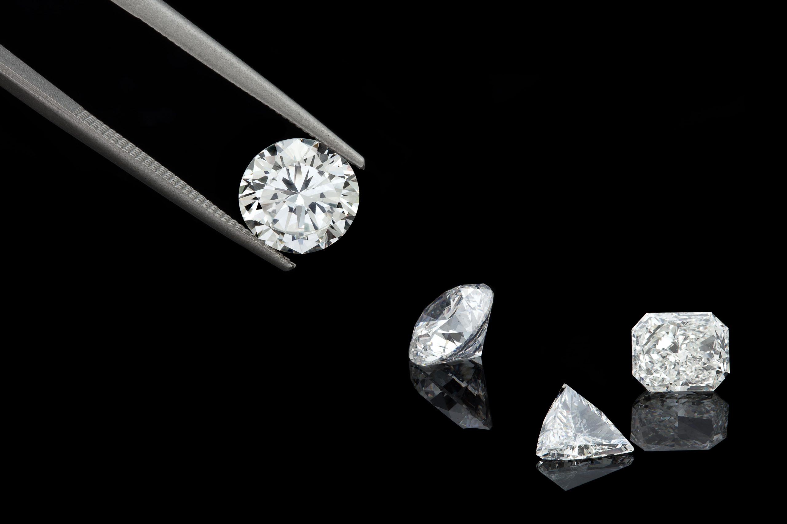 loose diamonds being held by tweezers